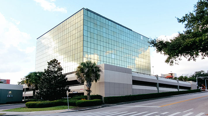 InTouch-GPS-Office-Building-Image InTouch GPS- glass office building on a corner surrounded by trees